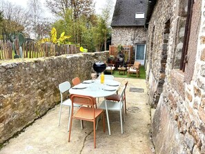 Enjoy al fresco dining and relaxation in this serene outdoor space with a barbecue grill and comfortable seating for four.