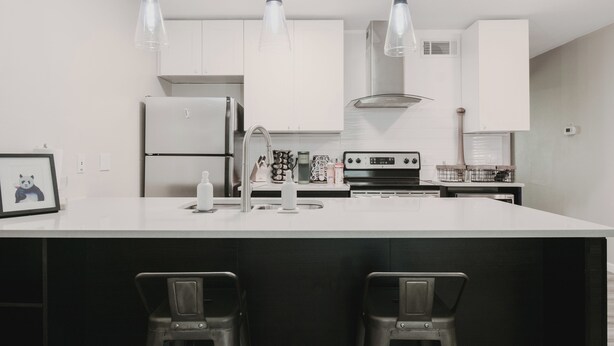 A modern kitchen with white cabinets, a central island with bar stools, and pendant lighting. - Cozy Central Austin Getaway, Pool, Wi-Fi, Free Parking, Near Downtown, So Co. (Austin)
