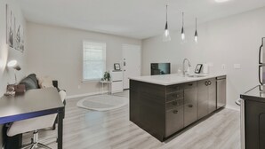 A modern kitchen with a central island, pendant lights, and a dining area with a table and chairs. - Cozy Central Austin Getaway, Pool, Wi-Fi, Free Parking, Near Downtown, So Co. (Austin)