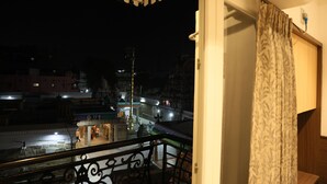 A balcony with a view of a temple and street at night. - Eagle Stay Inn (Kanchipuram)