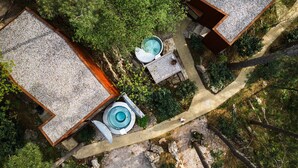 Vue aérienne d’un complexe hôtelier comprenant deux chalets, une piscine et un sentier pédestre bordé d’arbres.