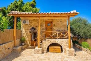 Un bâtiment en pierre avec un porche en bois, une porte et une petite boîte en bois.