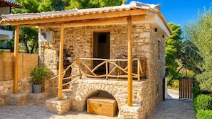 Un bâtiment en pierre doté d’un porche en bois et d’une petite boîte en bois.