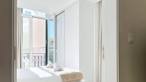 Un dormitorio con cama, ventana y vista al exterior.