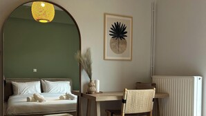 Een hotelkamer met een groot bed, een bureau, een stoel, een spiegel en een radiator.