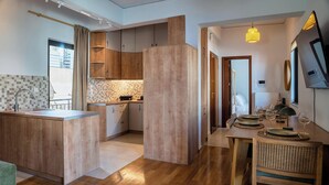 Een moderne keuken met houten kastjes, een inbouw eiland en een eethoek met een tafel voor vier personen.