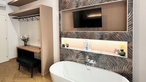A modern bathroom with a freestanding bathtub, a vanity with a mirror, and a wall-mounted TV. - ALL IN ROME RE DI ROMA (Rome)