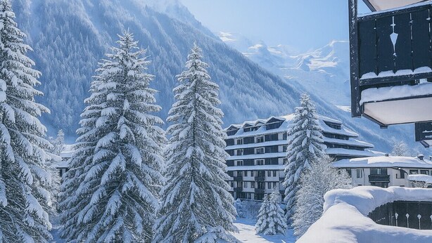 A snow-covered mountain landscape with a building featuring multiple balconies and a snow-covered roof. - Escape in Chamonix, breathtaking view Mont-Blanc (Chamonix-Mont-Blanc)