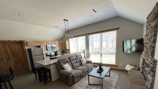 A modern kitchen with wooden cabinets, a built-in microwave, and a large island.