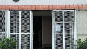 Ingresso di un hotel con un cartello che riporta "JO HOMETEL" e una insegna thailandese parzialmente visibile.