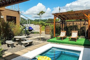 Relax by the pool surrounded by a shaded pergola and lounge chairs.