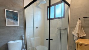 A modern bathroom with a glass-enclosed shower, a toilet, and a sink. - Cabana Mulungu (Fernando de Noronha)