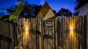 A wooden fence with a sign reading 'MULUNGU' and two wall-mounted lights. - Cabana Mulungu (Fernando de Noronha)