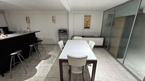 Une cuisine moderne avec un coin repas, un bar et un réfrigérateur.