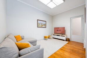 Relax in this stylish living room with a sofa, entertainment unit, and flat-screen TV.