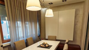 Un espace repas moderne avec une table blanche, six chaises et un centre de table composé de biscuits.