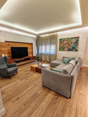 Luxury-Apartment, Gartenblick | Wohnbereich | 55-Zoll-Flachbildfernseher mit Kabelempfang, Netflix, Streaming-Dienste