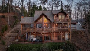 A multi-story log cabin with a balcony on the upper floor, surrounded by trees. - Beautiful, private, Blue Ridge, GA cabin with incredible views.  (Blue Ridge)