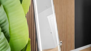 Une pièce avec un mur recouvert de lambris en bois, une porte blanche et une plante verte.