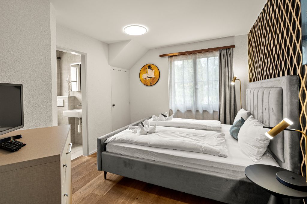 Une chambre à coucher moderne avec un lit, une table de chevet et un téléviseur.