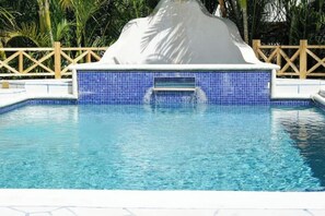 A swimming pool with a white hot tub and a blue tiled wall. - Relax in peace and comfort in a 1-bedroom Flat in Christ Church with WiFi, AC (Oistins)
