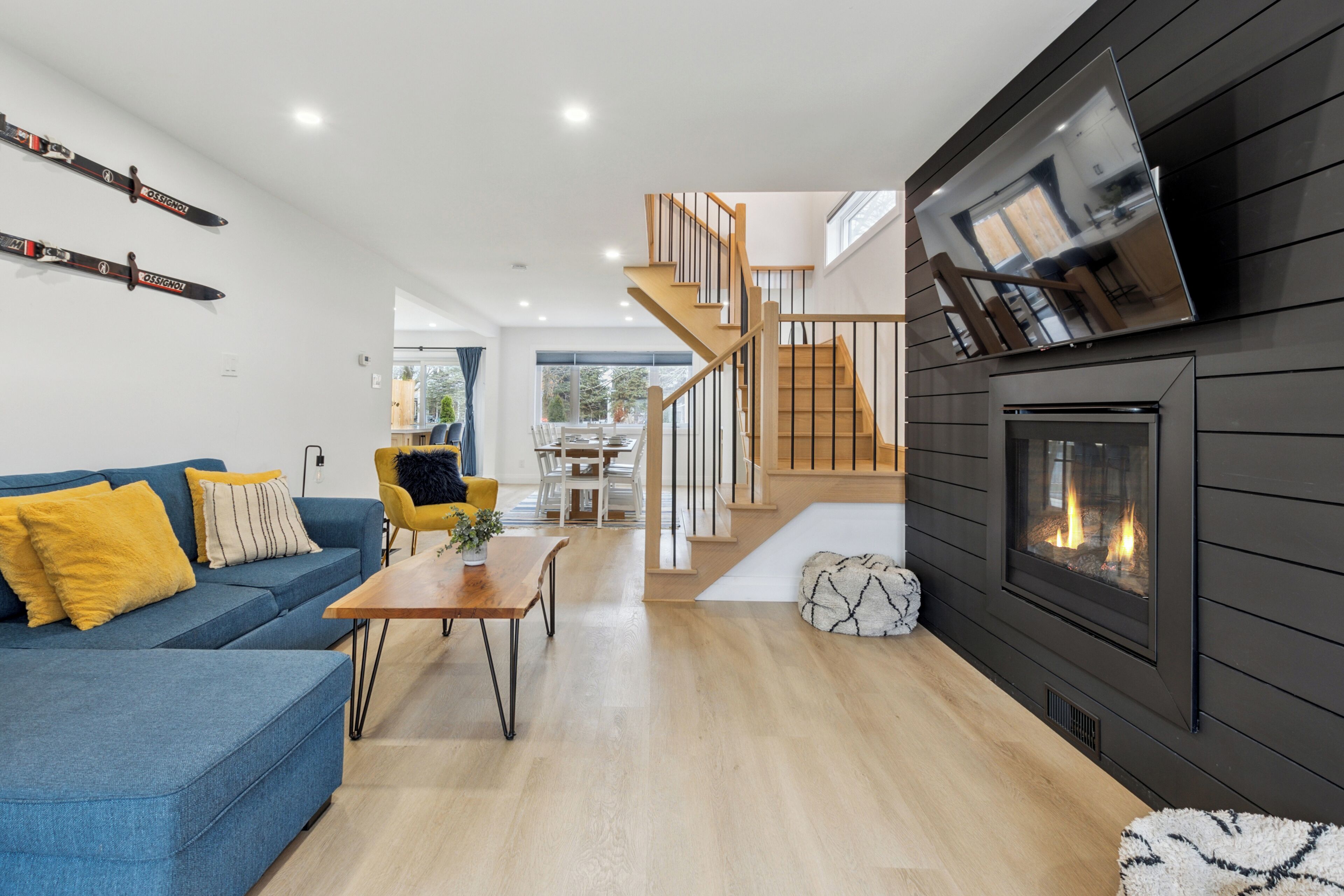 A modern living room with a blue sofa, wooden coffee table, and a fireplace.