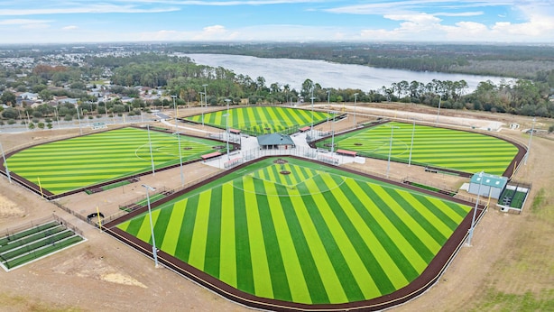 An aerial view of a sports complex with multiple fields and a stadium.