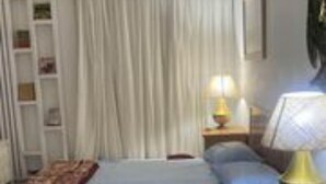 A bedroom with a bed, a nightstand with a lamp, a couch, and a window with curtains. - Hurghada town center marina suite at the Sheraton Plaza beach spa gym pool  (Hurghada)