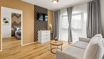 A modern living room with a sofa, a coffee table, a TV, and a decorative wall panel.