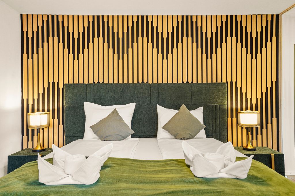 Ein Hotelzimmer mit einem Bett, zwei Nachttischen und einer Wand mit vertikalen Holzlamellen.