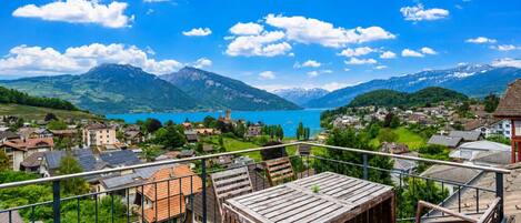 Ein Balkon mit Blick auf eine gebirgige Landschaft und einen See.