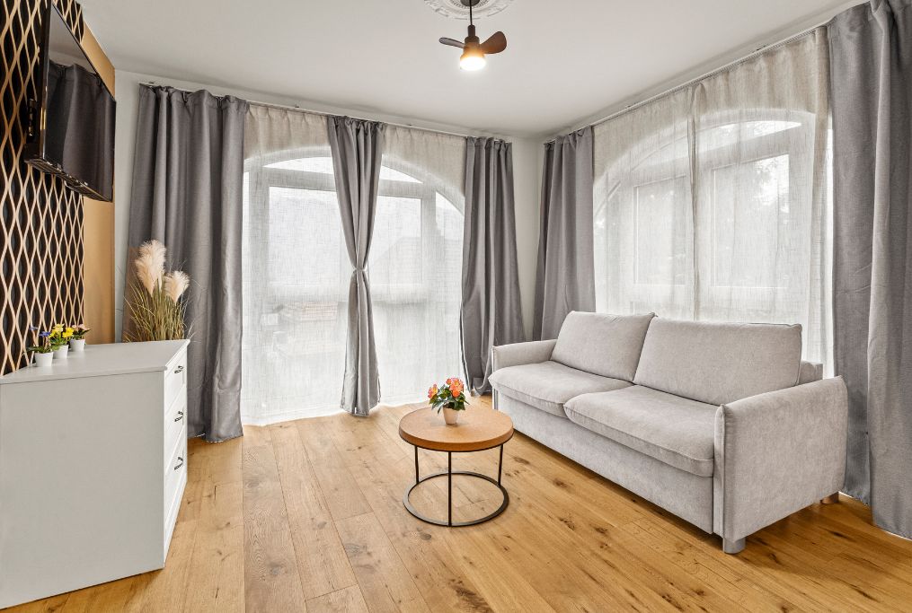 A modern living room with a sofa, a round coffee table, and a TV on a stand.