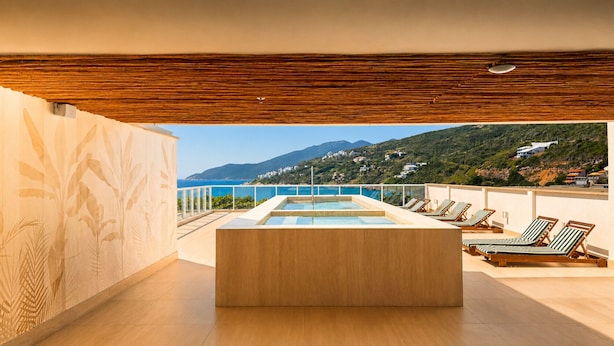Zona de piscina interior moderna con vistas al paisaje costero.
