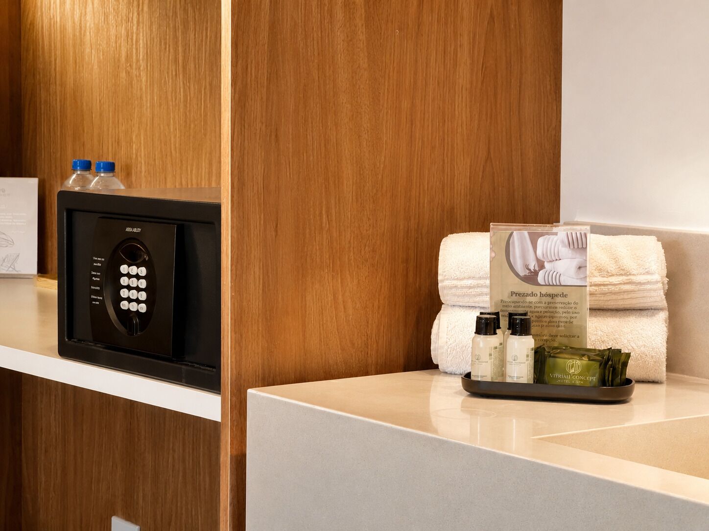 A hotel reception area with a digital keypad, a stack of towels, and toiletries on a tray.