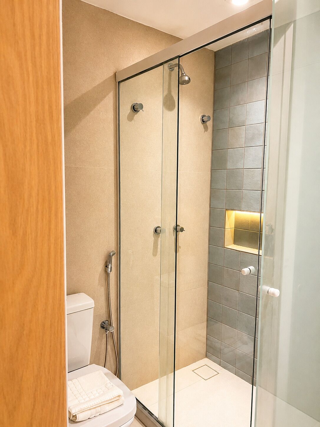 Un baño moderno con ducha de vidrio, inodoro y barra para toallas.