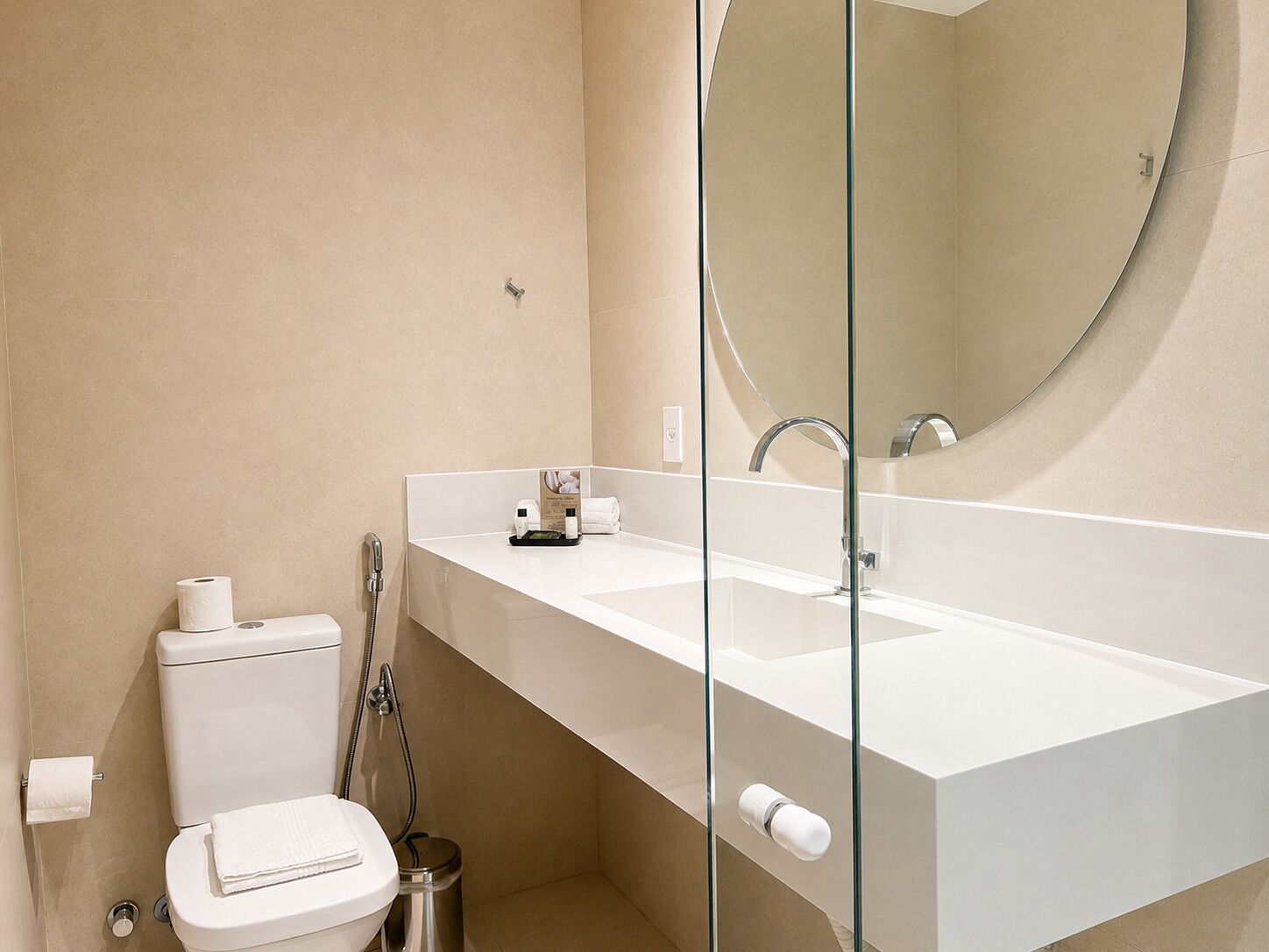Een moderne badkamer met een wit wastafelmeubel, spiegel en toilet.