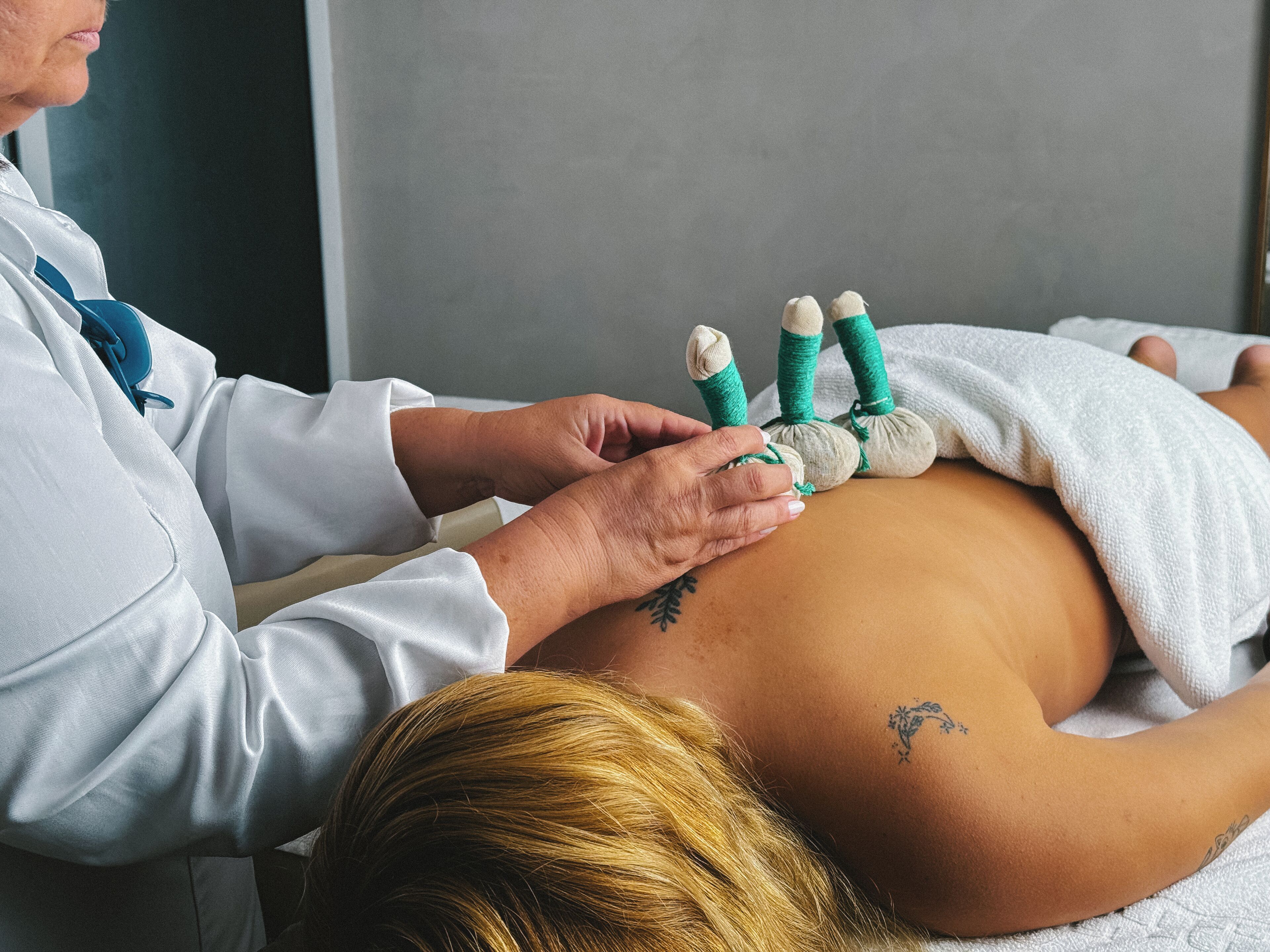A person receiving a physical therapy treatment with a therapist's hands on their abdomen.