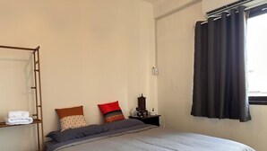A bedroom with a bed, a wooden ladder, a nightstand, a lamp, and a window with curtains. - Located at CBD Rama 9 convenience area. Private Room with Share bath (Krung Thep Maha Nakhon)
