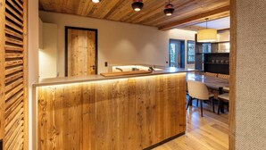Une cuisine moderne avec des éléments en bois, un îlot central et des luminaires suspendus.