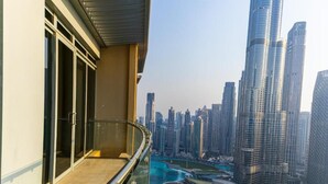 A high-rise building with a glass balcony overlooking a cityscape. - Paradise View Holiday Homes L.L.C. (Dubai)