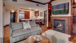 A modern living room with a grey sofa, a coffee table, and a fireplace. - Constellation #404 Ski-in & Out @ Northstar (Truckee)