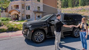 A black SUV parked in front of a building with a stone facade and a balcony. - Constellation #404 Ski-in & Out @ Northstar (Truckee)