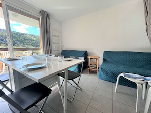 Une pièce moderne comprenant une table à manger, des chaises, un canapé et une petite table d’appoint.