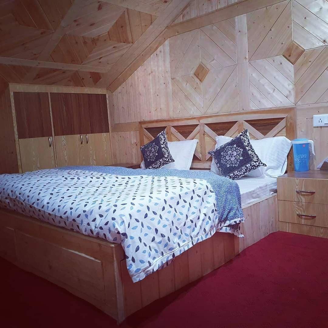 Una habitación con paneles de madera, una cama, una mesita de noche y un armario.