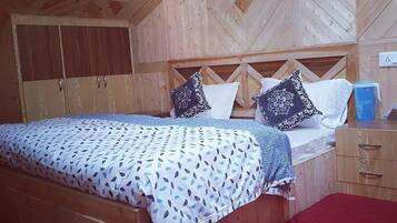 Una habitación con paneles de madera, una cama, una mesita de noche y un armario.