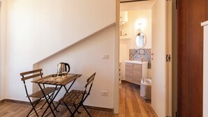 Une cuisine de taille réduite, avec un mur recouvert de carreaux, un meuble en bois et un luminaire suspendu.