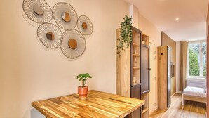 Une cuisine moderne avec une table en bois, une plante en pot et un élément décoratif fixé au mur.