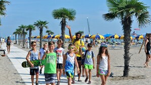 A beach walkway with palm trees and umbrellas. - Isaresidence three-room apartment Prestige Suite for 4 persons (Isolaverde di Chioggia)