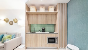 Une cuisine moderne avec des meubles en bois, un four à micro-ondes et un revêtement mural vert.