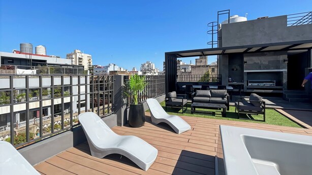 Une terrasse sur le toit, dotée d’un espace salon, d’un barbecue et offrant une vue sur le paysage urbain.